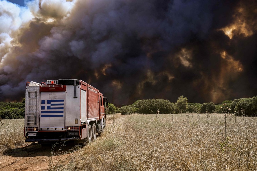 Um caminhão de bombeiros chega ao assentamento de Pournari durante incêndios florestais na área de Magoula, a cerca de 25 km de Atenas.