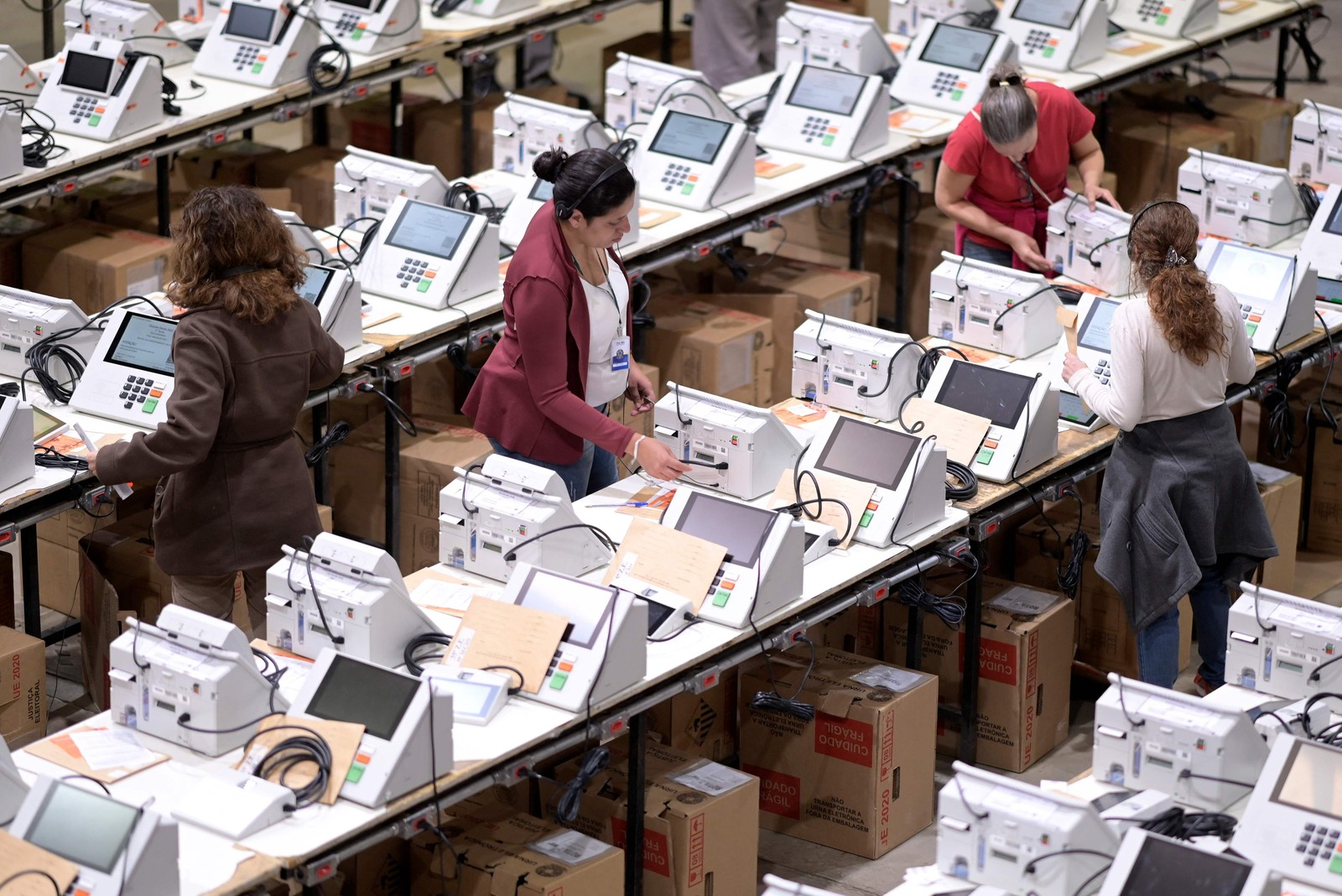 Trabalhadores preparam cédulas eletrônicas para serem utilizadas durante as eleições presidenciais de 2 de outubro no Tribunal Regional Eleitoral em Belo Horizonte, Minas Gerais — Foto: DOUGLAS MAGNO / AFP