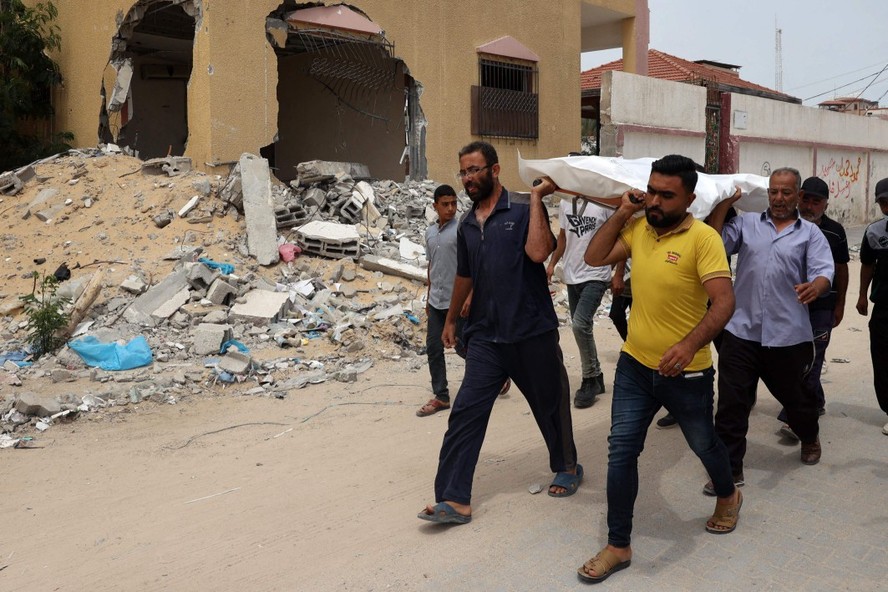 Homens carregam um corpo encontrado nas imediações do complexo hospitalar Nasser, na Faixa de Gaza