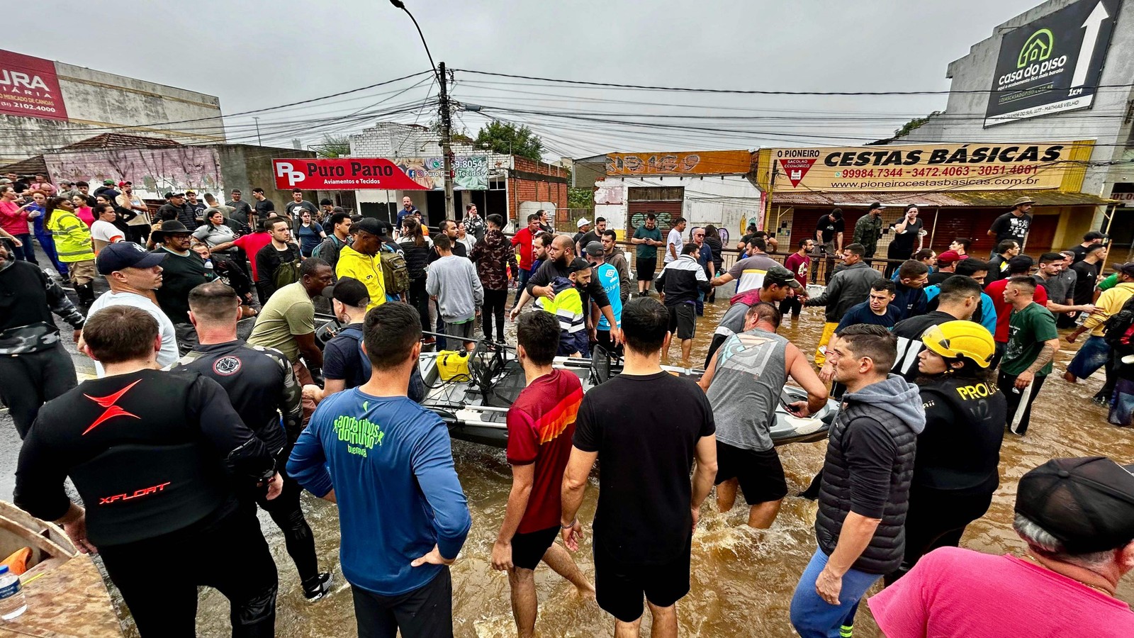 Esta foto divulgada pela Prefeitura de Canoas, município do Rio Grande do Sul, mostra equipes de resgate e voluntários ajudando vítimas de enchentes. — Foto: Alisson Moura / Prefeitura de Canoas / AFP