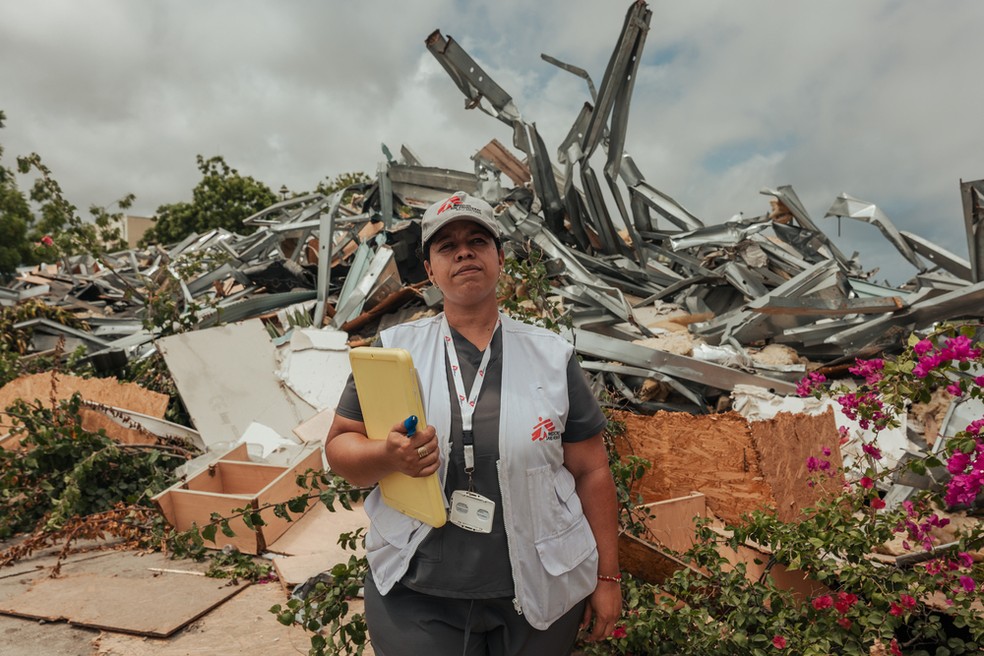 Arelys, agente de saúde comunitária da organização Médicos Sem Fronteiras (MSF), caminha diante de fileiras de prédios residenciais demolidos durante atividades de extensão comunitária e promoção da saúde na região de Playa Grande. — Foto: Adriana Loureiro Fernandez/MSF