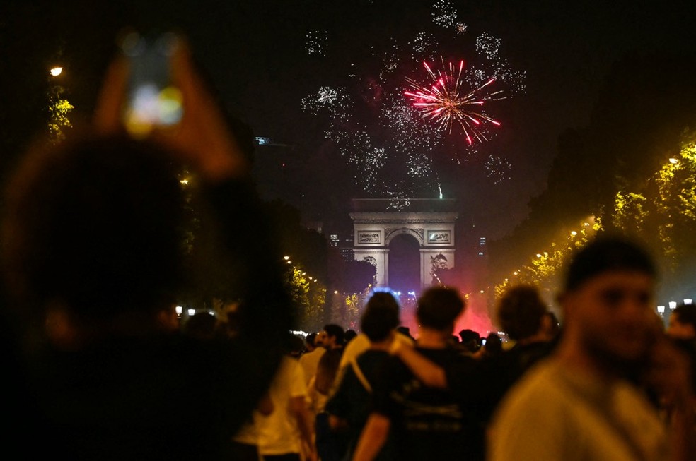 Torcedores do Paris Saint-Germain comemoram com fogos de artifício após o PSG vencer a final da Liga dos Campeões — Foto: LOU BENOIST / AFP
