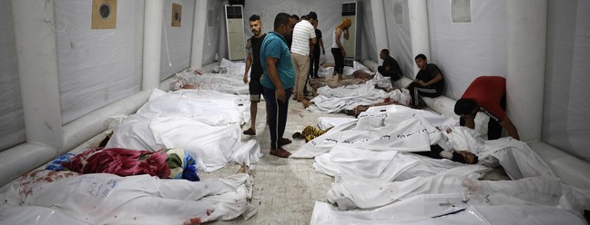 Corpos de palestinos mortos em ataques aéreos israelenses no hospital Ahli Arab, no centro de Gaza — Foto: Dawood NEMER/AFP