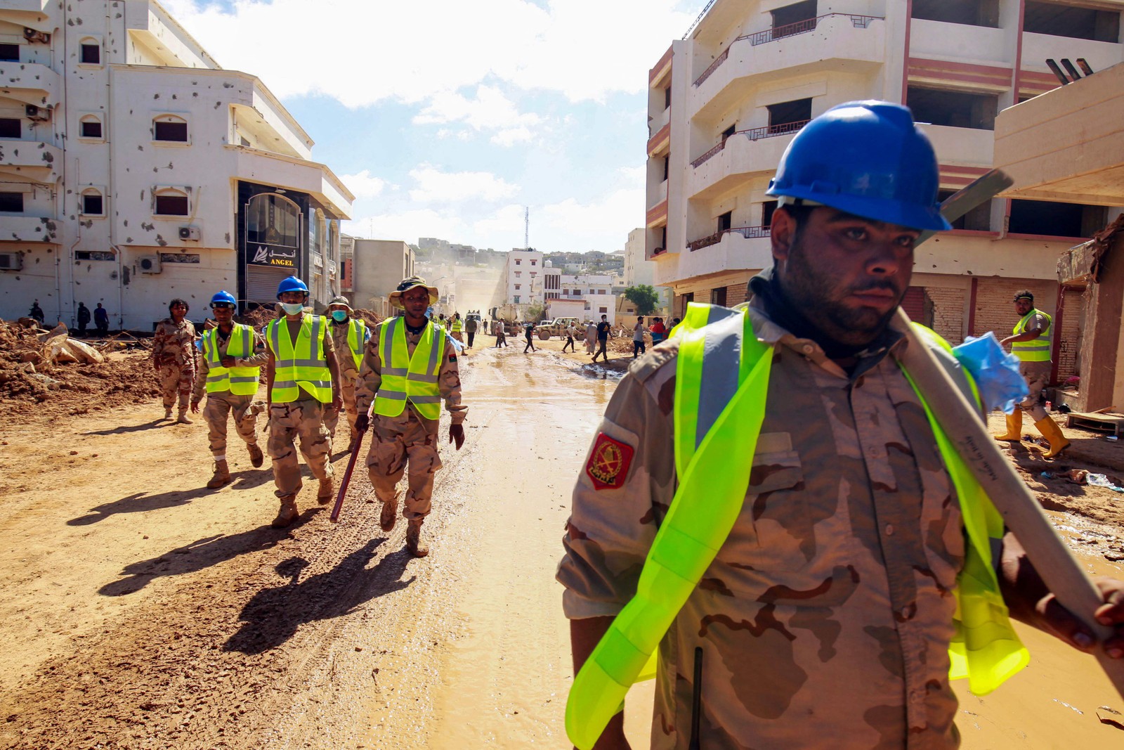 Equipes de resgate caminham ao longo de uma área danificada por uma enchente repentina em Derna Na Líbia. — Foto: Abdullah DOMA/AFP