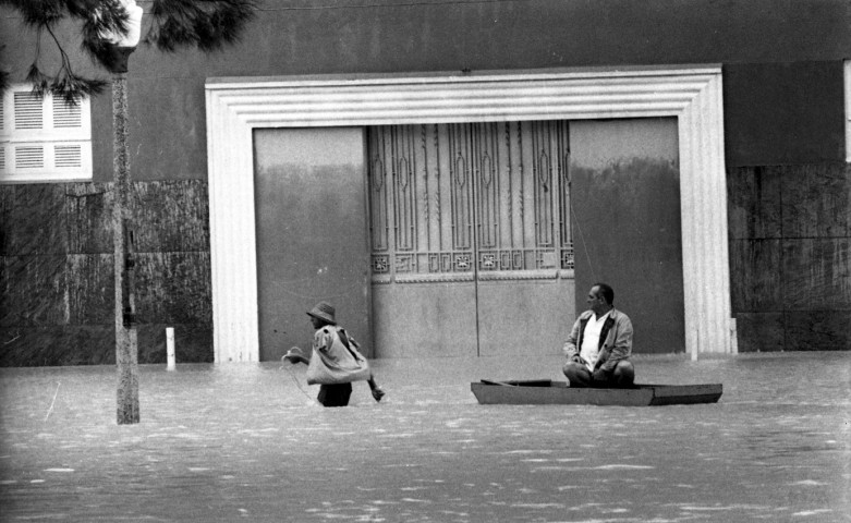 Homem puxa barco com morador na rua alagada na Gávea — Foto: Arquivo / Agência O Globo