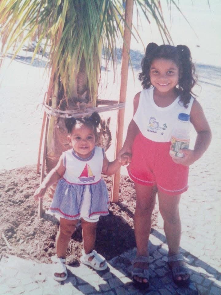 Juliana, com 2 anos, na companhia da irmã Mariana (criança maior) brincando na praia; longe das telas de celulares — Foto: Álbum de família