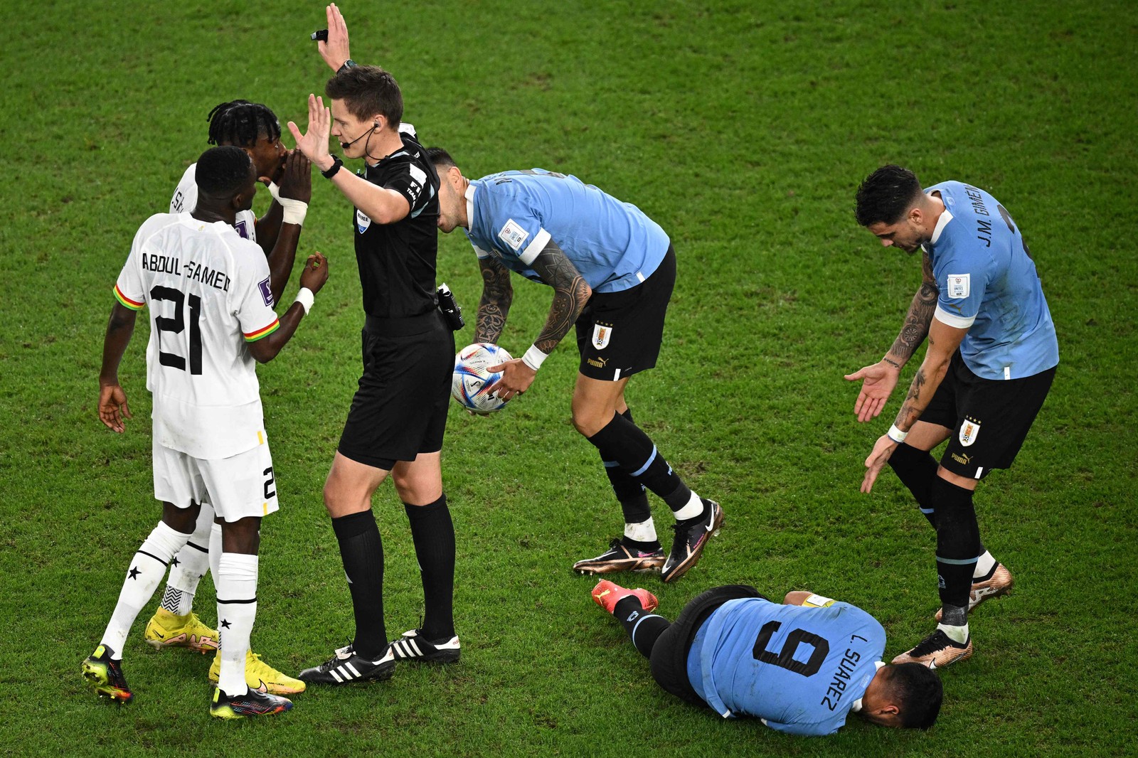 Árbitro alemão Daniel Siebert interfere enquanto Suárez fica caído ao chão — Foto: PHILIP FONG/AFP