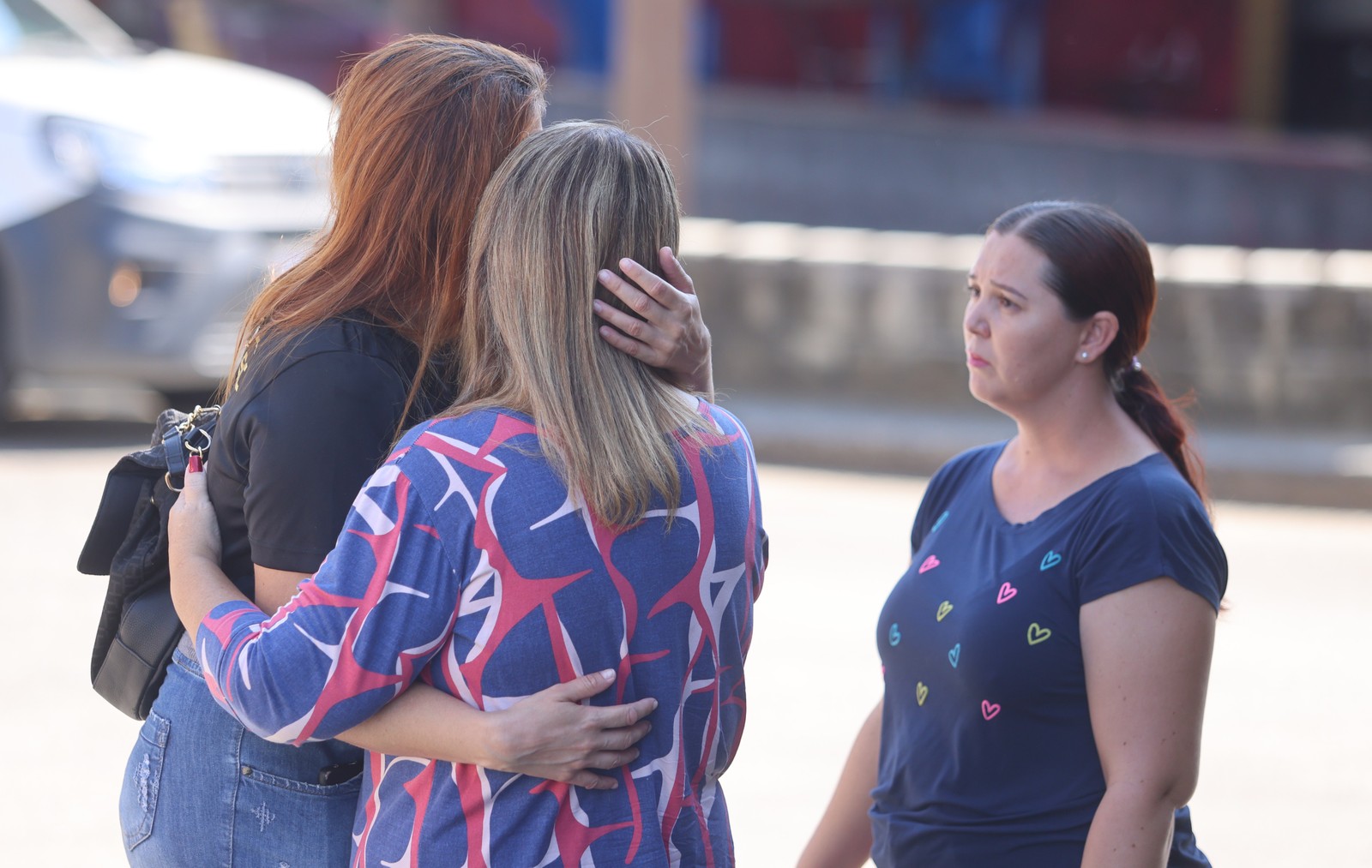 Na foto, Tais Oliveira (de preto) segura a irmã de Daniel Patrício Oliveira — Foto: Fabiano Rocha / Agência O Globo