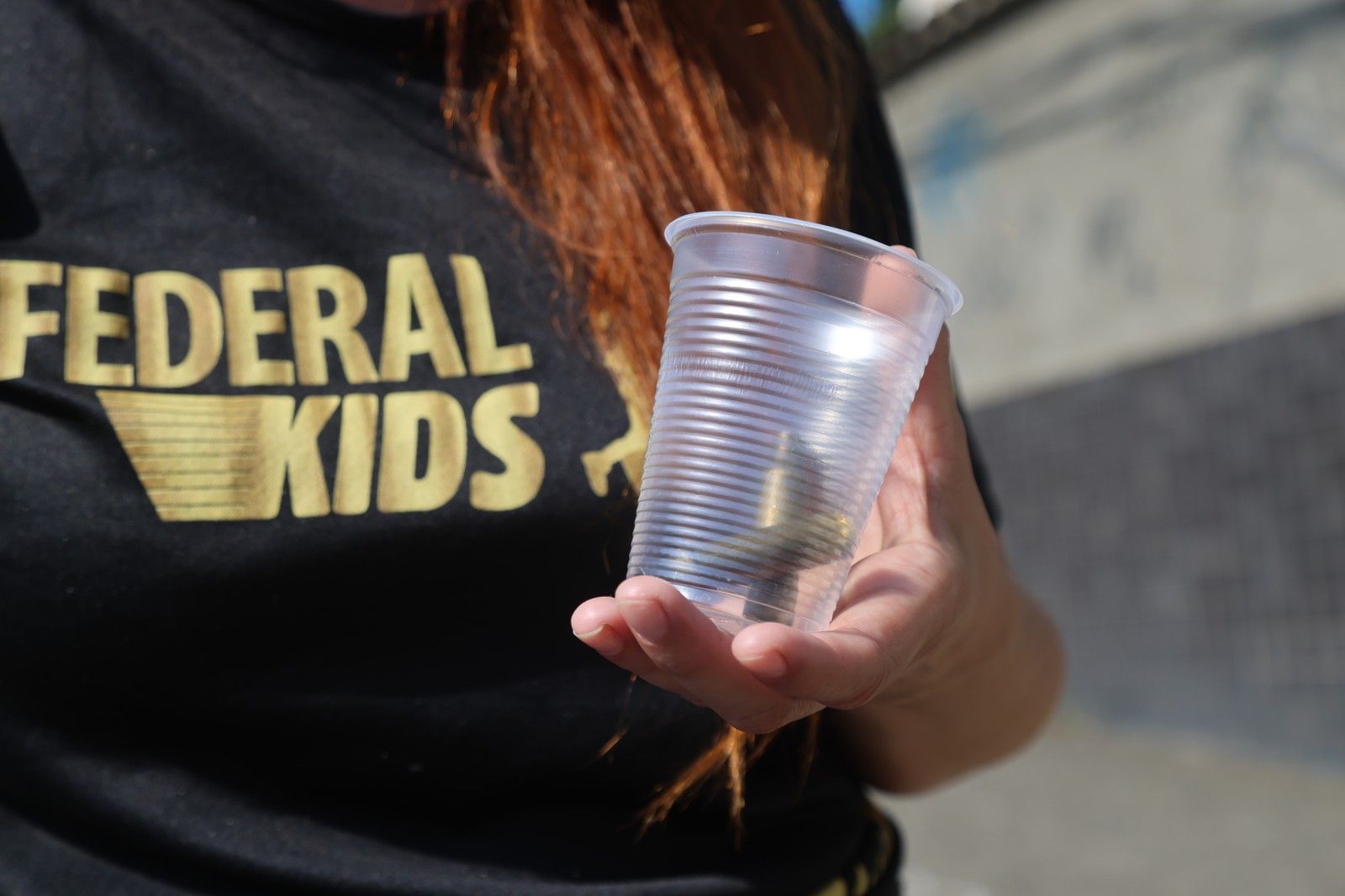 Tais Oliveira segura as cápsulas que encontrou no local onde o irmão foi morto — Foto: Fabiano Rocha / Agência O Globo