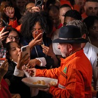 Presidente Lula distribui pão de queijo para apoiadores durante um evento na Refinaria Gabriel Passos, em Betim — Foto: Douglas MAGNO / AFP