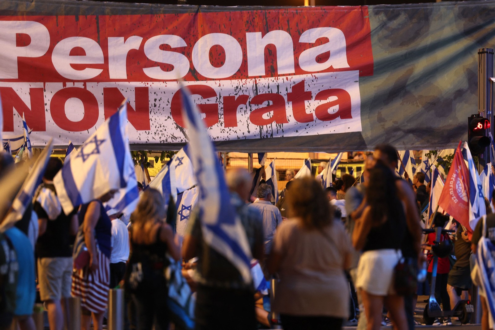 Manifestantes levantam uma faixa durante uma manifestação contra o plano de revisão judicial do governo israelense em Tel Aviv — Foto: Jack Guez/AFP
