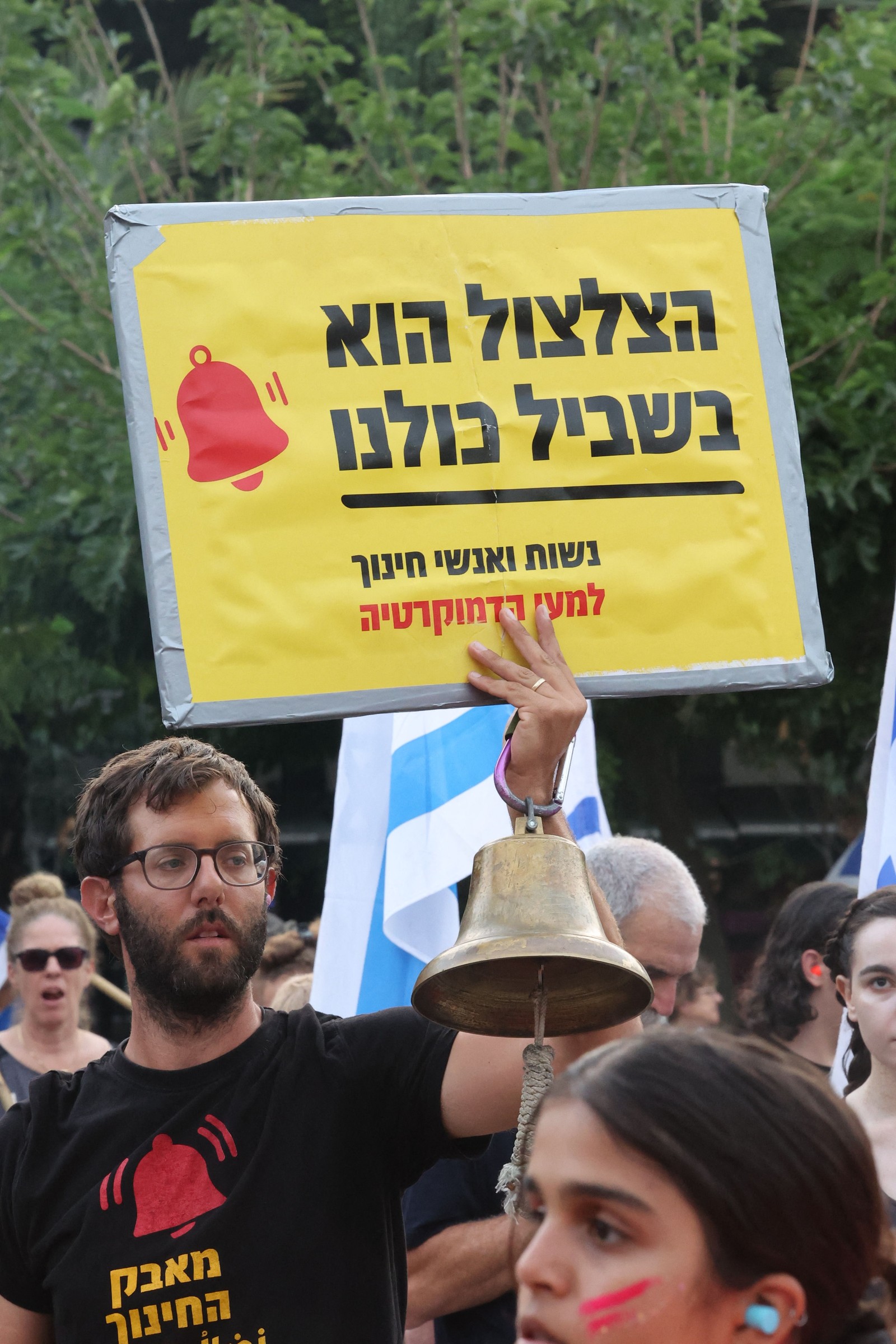 Um manifestante levanta um cartaz durante uma manifestação contra o plano de revisão judicial do governo israelense em Tel Aviv — Foto: Jack Guez/AFP