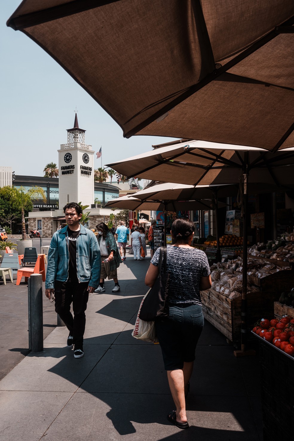 Pessoas caminham pelas barracas do Farmers Market, uma feira livre que funciona dentro do centro comercial The Grove LA, em Los Angeles — Foto: Gabriela Bhaskar/The New York Times