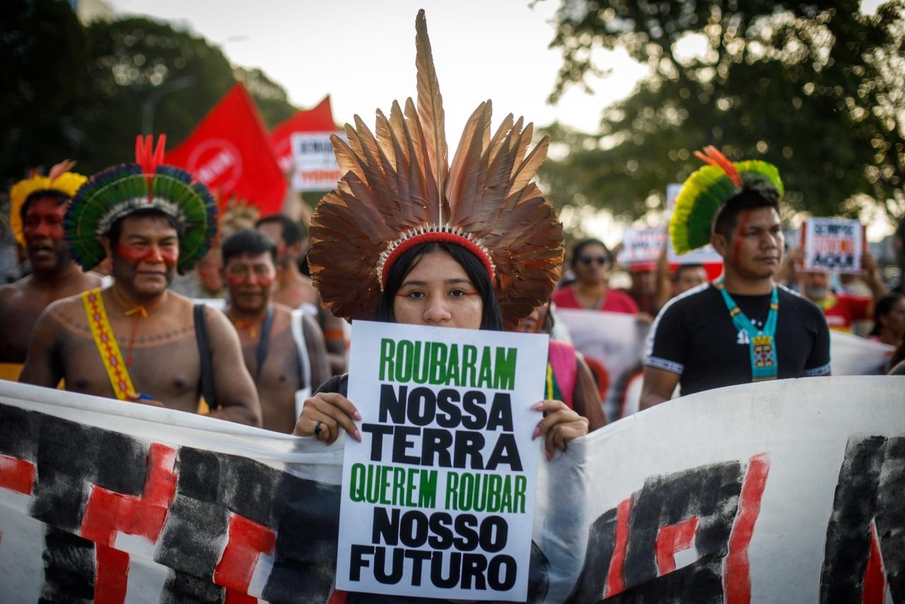 "Roubaram nossa terra, querem roubar nosso futuro", diz cartaz em ato — Foto: Brenno Carvalho/Agência O Globo
