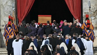 Carregadores, ao lado de guardas suíços, carregam o caixão do Papa Francisco durante o transporte da capela de Santa Marta para a Basílica de São Pedro — Foto: AFP