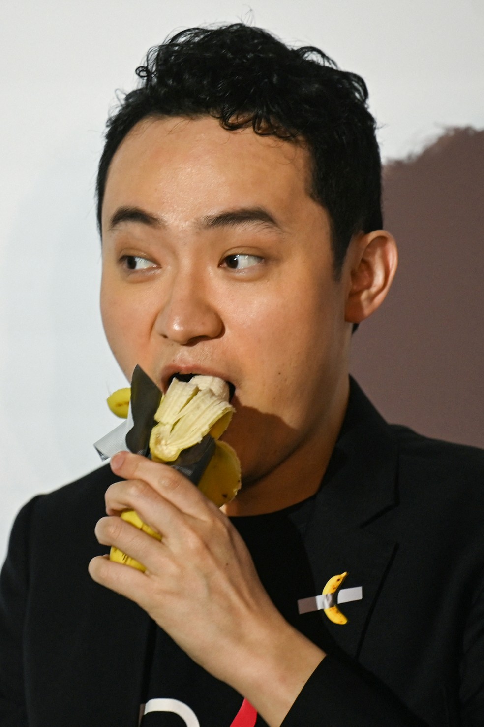 Justin Sun come uma obra de arte de banana composta por uma banana fresca presa a uma parede com fita adesiva  Foto: AFP