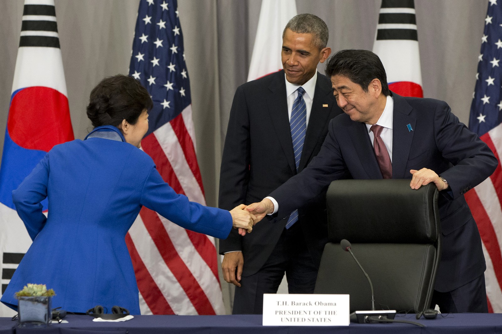 A então presidenta sul-coreana Park Geun-hyecumprimenta o primeiro-ministro japonês Shinzo Abe diante de Barack Obama, presidente dos EUA, após sua reunião na Cúpula de Segurança Nuclear em Washington — Foto: Arquivo