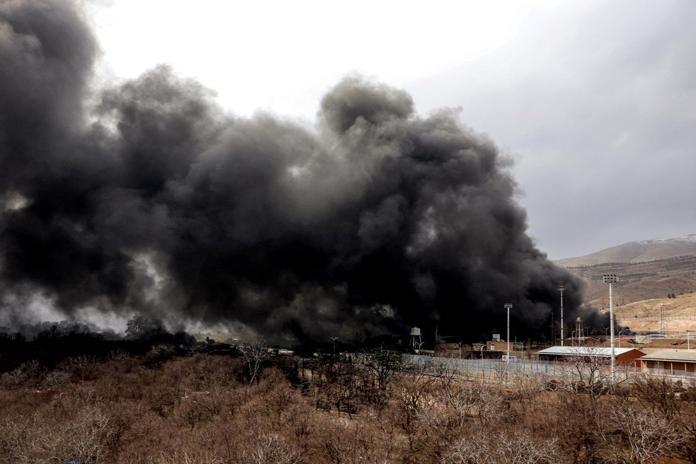 Uma nuvem de fumaça sobe de um incêndio em curso após um ataque aéreo durante a noite à refinaria de petróleo de Shahran, no noroeste de Teerã, em 8 de março de 2026 — Foto: AFP