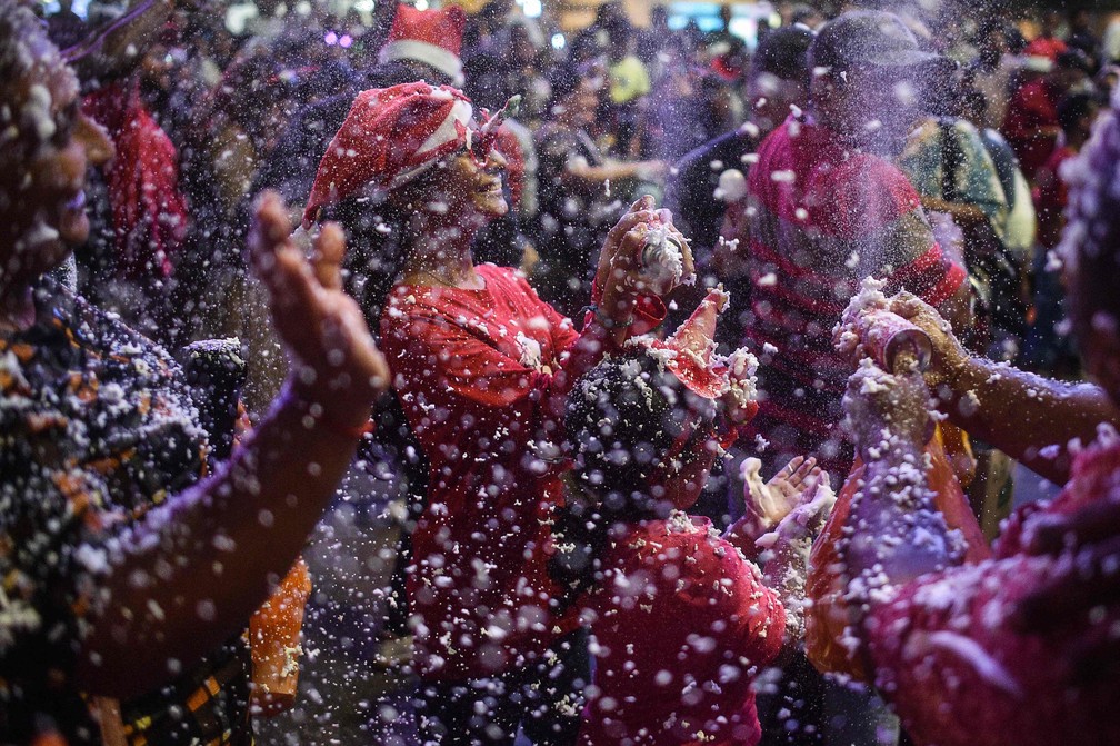 Pessoas brincam com neve artificial feita de espuma m Kuala Lumpur, na Malásia — Foto: AFP/Arif Kartono