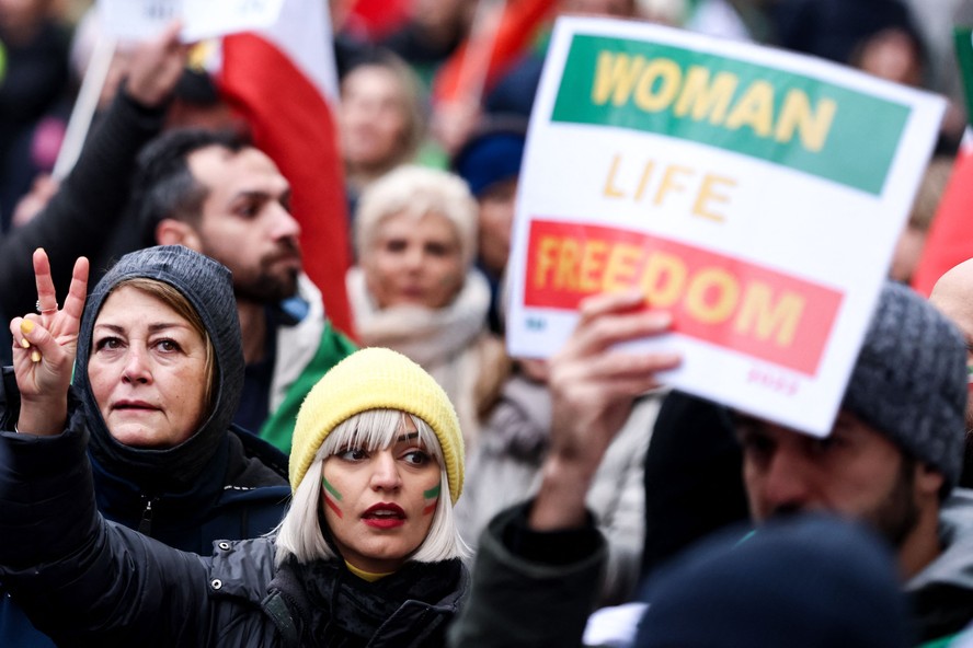 Manifestante com a bandeira iraniana pintada no rosto participa de protesto em apoio ao movimento de resistência das mulheres do Irã em Bruxelas
