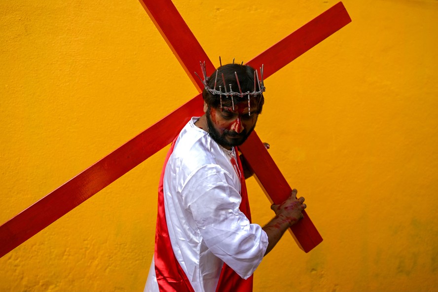 Homem reencena a crucificação de Jesus Cristo enquanto participa de uma procissão religiosa na Sexta-Feira Santa, em Chennai, na Índia