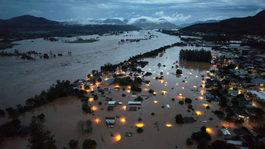 As fortes chuvas fizeram transbordar o Rio Taquari, inundando a cidade de Encantado e deixando à vista apenas os tetos das casas e os pontos de luz dos postes