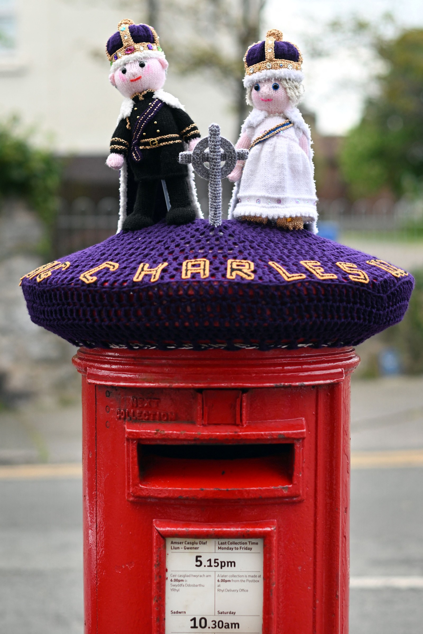 Uma caixa de correio decorada com um tricotado do rei britânico Charles III e da rainha Camilla, em Rhyl, norte do País de Gales — Foto: Paul ELLIS / AFP