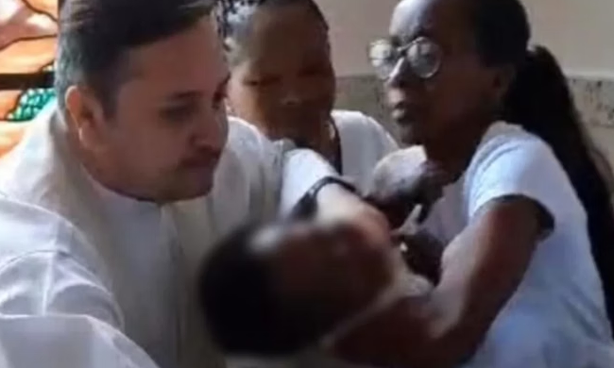 Família presta queixa contra padre que deu puxão em bebê durante batizado, na Região Serrana do Rio