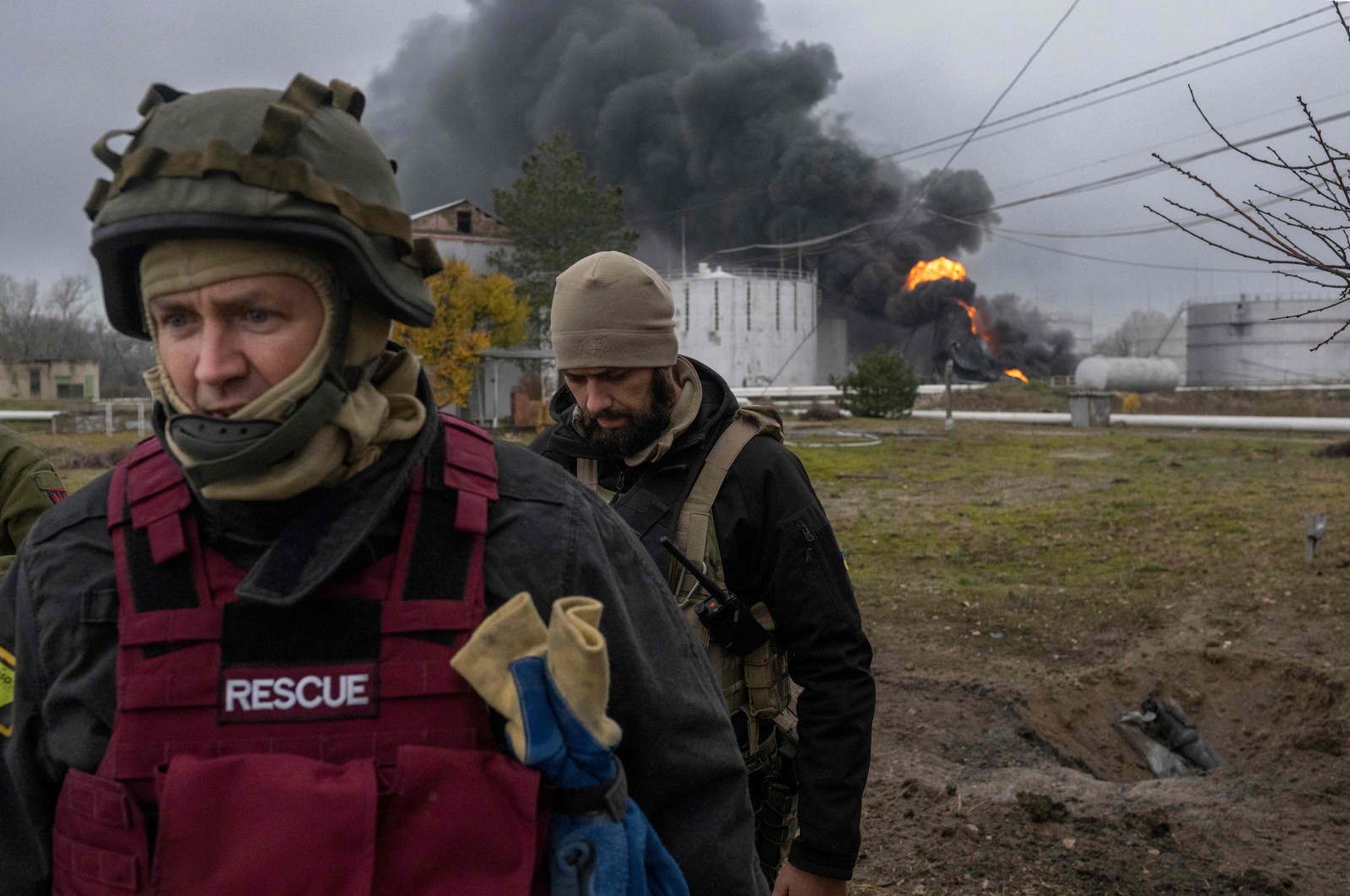 Soldados inspecionam área enquanto a fumaça negra sobe de uma reserva de petróleo em Kherson — Foto: BULENT KILIC/AFP