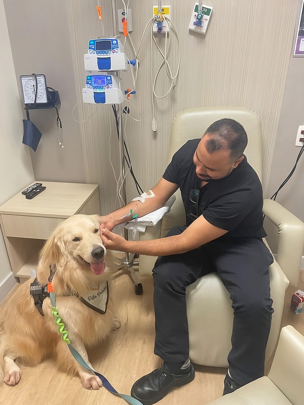 Dasa Oncologia.Paciente faz carinho em Bento enquanto recebe tratamento na unidade na Gávea — Foto: Divulgação/Pêlo Próximo
