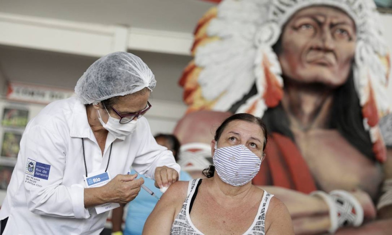 Mulher recebe vacina CoronaVac contra o novo coronavírus na sede do Cacique de Ramos, um dos blocos carnavalescos mais tradicionais do Rio de Janeiro — Foto: Ricardo Moraes / Reuters