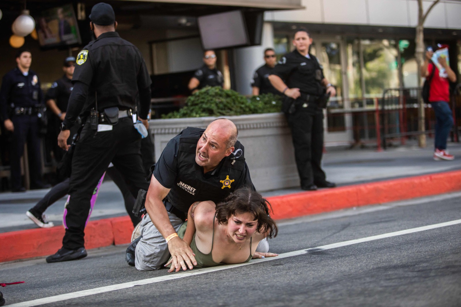 Policial do Serviço Secreto americano imobiliza manifestante no chão depois que ela correu em direção a uma carreata a caminho do Centro de Convenções de Los Angeles, onde os líderes norte e sul-americanos estão reunidos para a nona Cúpula das Américas em Los Angeles, em 8 de junho de 2022 — Foto: Apu GOMES / AFP