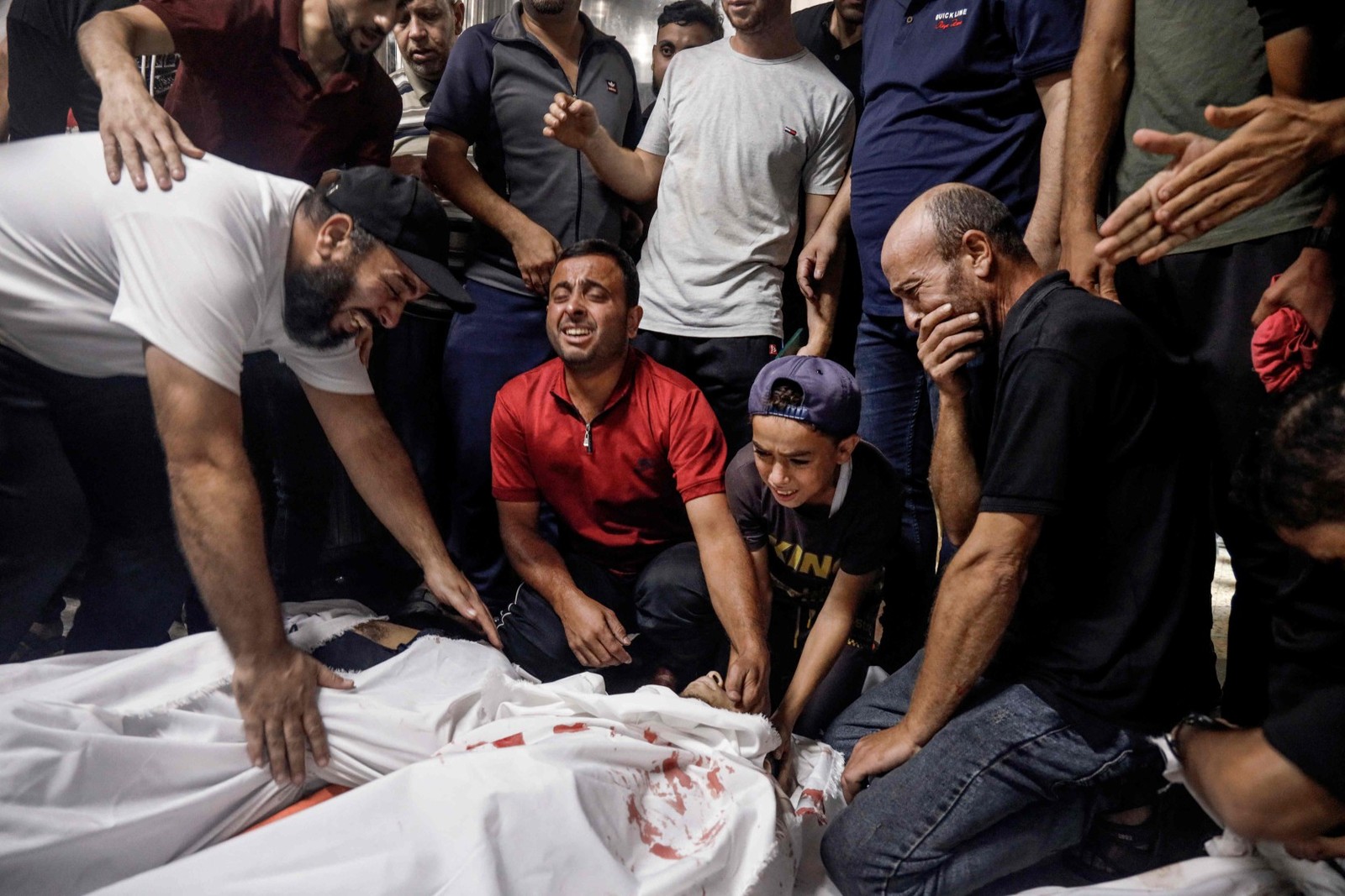 Familiares e parentes choram pelos corpos de militantes palestinos mortos – Eyad BABA / AFP