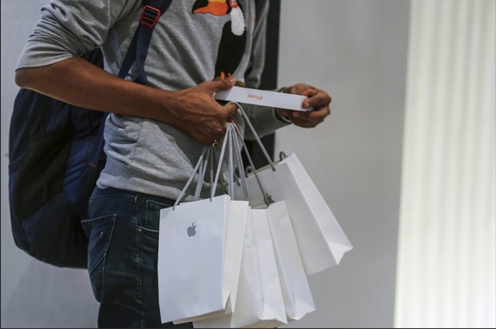 Um cliente com várias sacolas com produtos na Apple Store em Mumbai. — Foto: Dhiraj Singh/Bloomberg