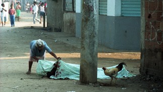 Uma moradora observa o corpo de uma das vítimas da chacina, em 30 de agosto de 1993 — Foto: André Durão / Agência O Globo