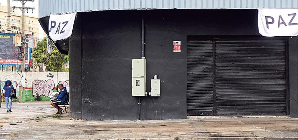 Rotina alterada. Na entrada da Vila Cruzeiro, faixas de “Paz” na fachada do comércio fechado são o retrato de uma comunidade que ainda não voltou ao normal — Foto: Fabiano Rocha