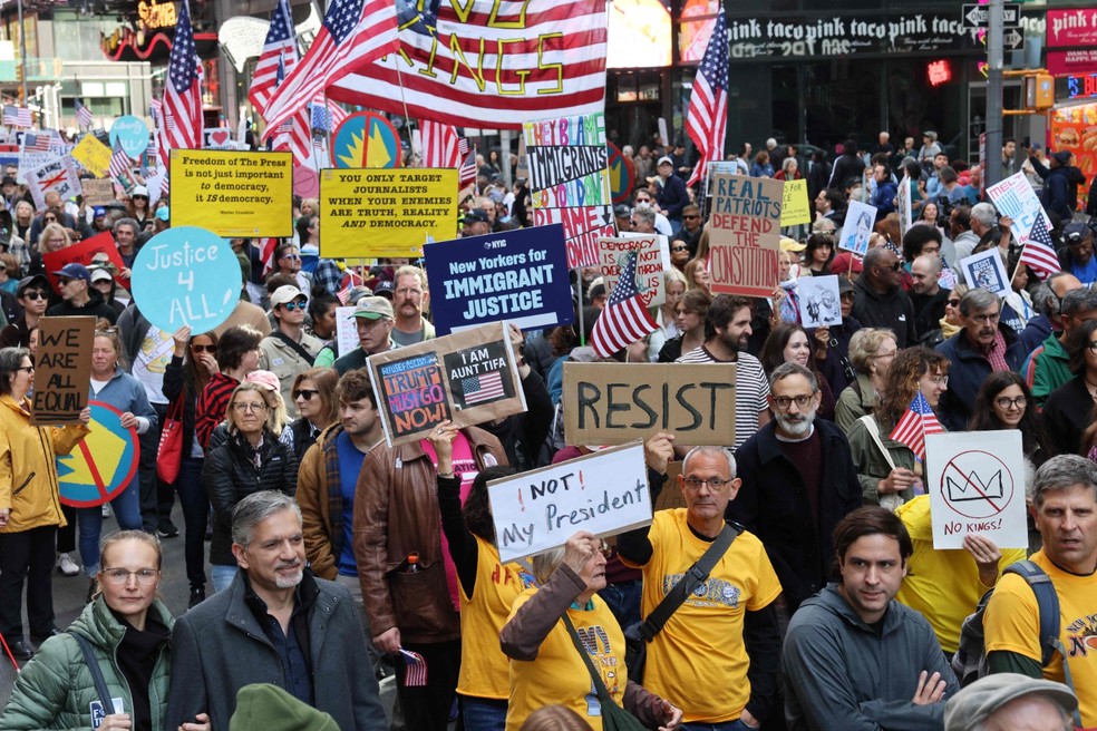 Cartazes como "Not my president" (Não é meu presidente) são vistos em meio a multidão — Foto: AFP