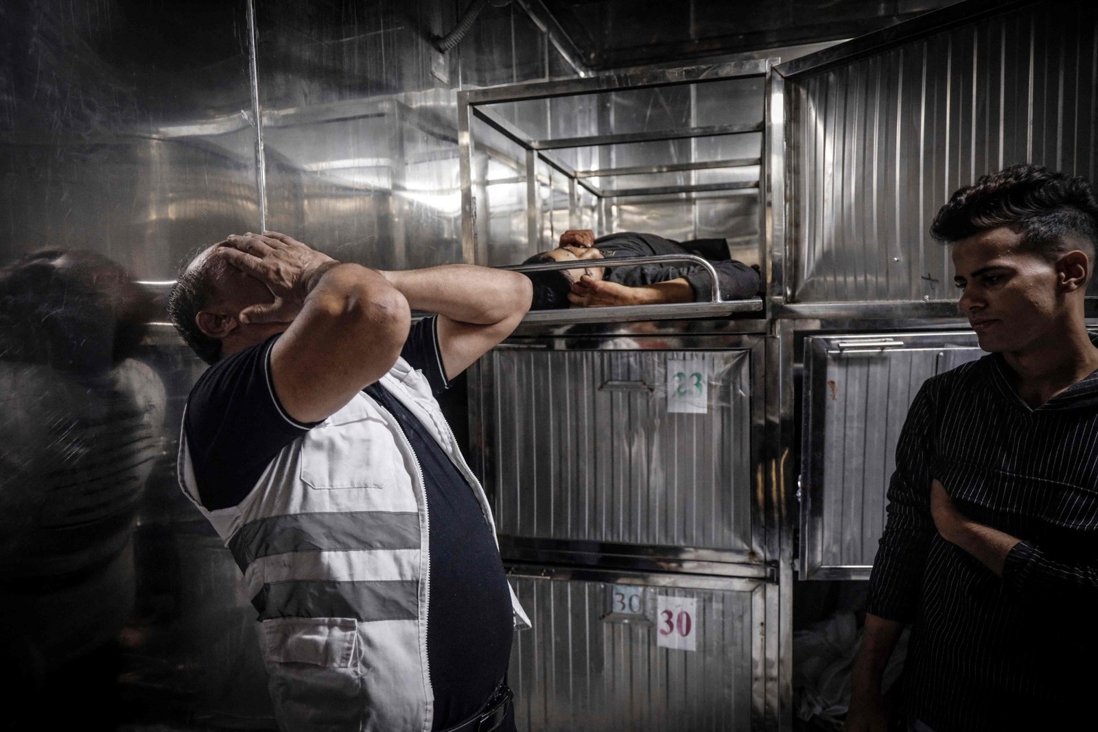 Homem chora ao lado do corpo de um dos militantes palestinos mortos – Eyad BABA / AFP