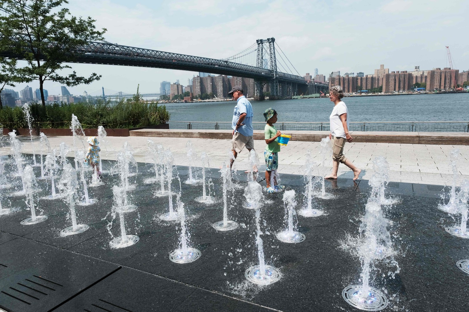 Pessoas tentam se refrescar em fonte pública durante uma onda de calor no bairro do Brooklyn, em Nova York.  — Foto: SPENCER PLATT / Getty Images via AFP