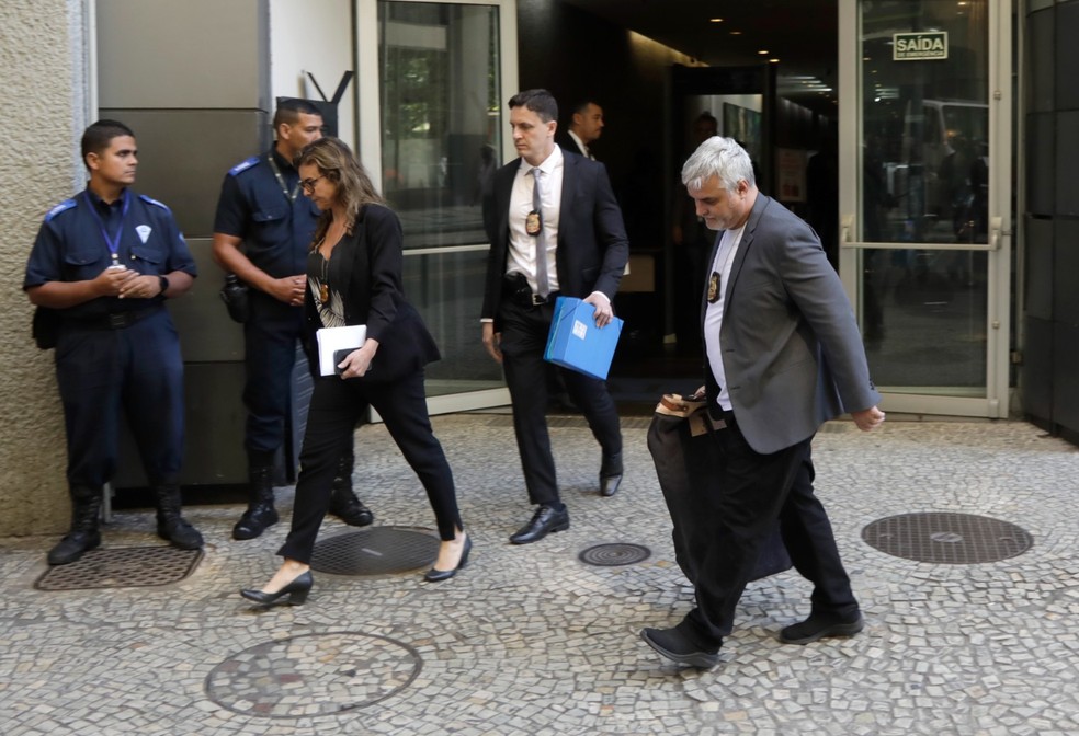 Policiais federais e procuradores deixam a Alerj com um malote contendo apreensões. — Foto: Gabriel de Paiva / Agência O Globo