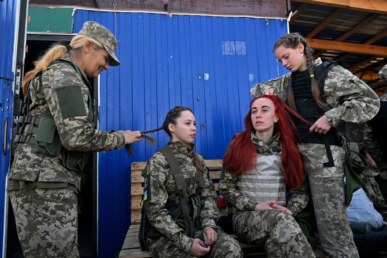 Cadetes ucranianas, usando novos uniformes militares projetados especialmente para mulheres, têm seus cabelos trançados enquanto participam de um treinamento durante o evento "Uniform matters" — Foto: Sergei SUPINSKY / AFP