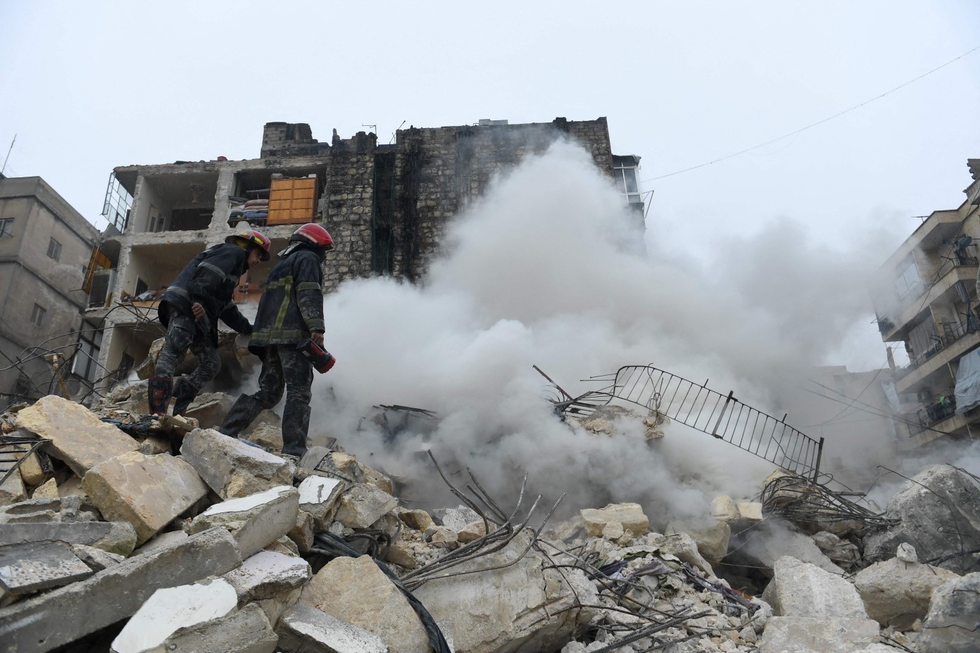 Equipes de resgate procuram sobreviventes sob os escombros de um prédio que desabou após o terremoto na cidade de Aleppo, norte da Síria — Foto: AFP