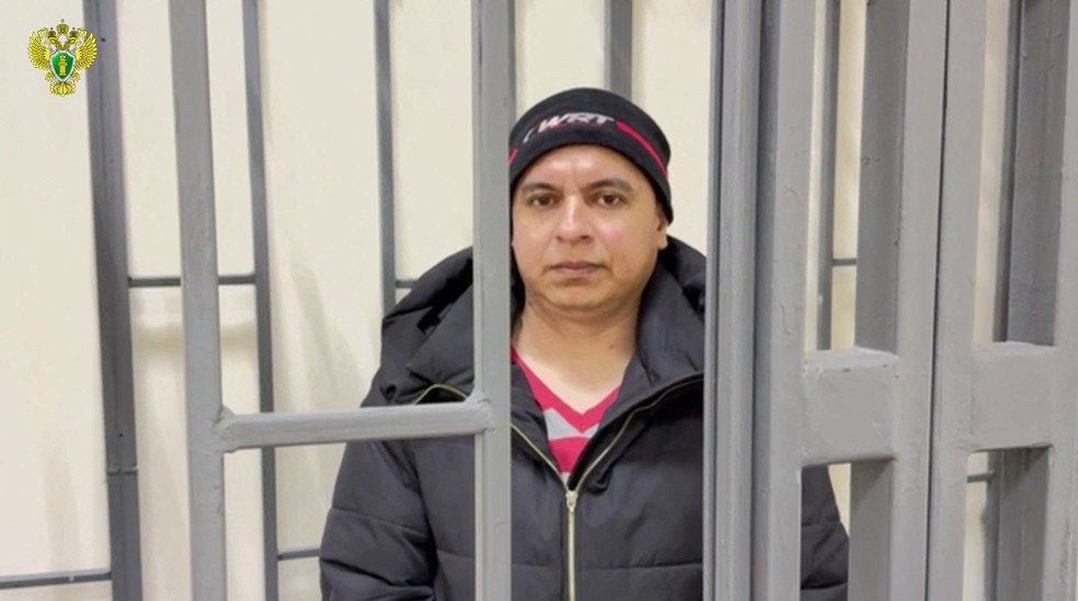 Nesta imagem retirada de um vídeo divulgado pelo Ministério Público russo, o colombiano José Aranda, acusado de participar em hostilidades ao lado das Forças Armadas da Ucrânia, comparece à audiência de julgamento num tribunal em Donetsk, na Ucrânia controlada pela Rússia — Foto: DIVULGAÇÃO / PROCURADORIA GERAL DA RÚSSIA / AFP