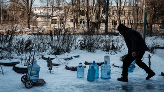 Andrej, de 51 anos, carrega galões de água depois de buscá-los em um ponto de fornecimento na cidade de Avdiivka, em meio à invasão russa da Ucrânia. — Foto: YASUYOSHI CHIBA / AFP - 08/02/2023