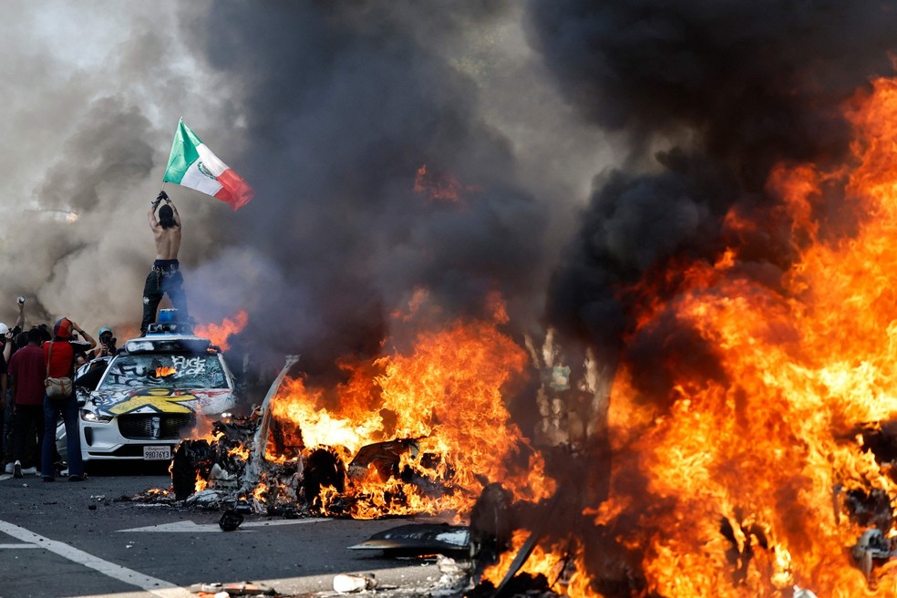 Manifestante segura bandeira mexicana durante protesto contra a polícia migratória dos EUA em Los Angeles — Foto: Mario Tama/Getty Images via AFP