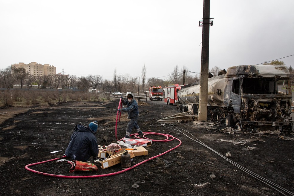 Trabalho de limpeza ao lado de um petroleiro danificado após ataques em Teerã no domingo — Foto: Arash Khamooshi / New York Times