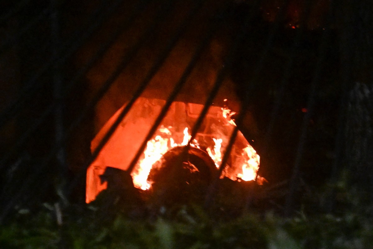 Um veículo em chamas na base aérea de La Carlota, em Caracas, após uma série de explosões em 3 de janeiro de 2026 — Foto: JUAN BARRETO / AFP