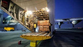 Pacotes com ajuda humanitária cedidos pela ONU para Gaza são colocados em avião no aeroporto de Dubai — Foto: Giuseppe CACACE / AFP