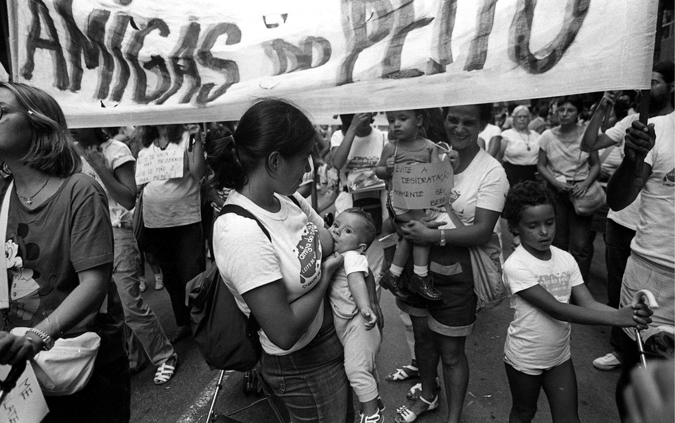 Mulher amamenta seu bebê durante passeata do Dia da Mulher em 1984 — Foto: Paulo Moreira/Agência O GLOBO