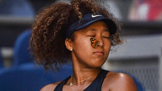 Borboleta pousa no rosto japonesa Naomi Osaka durante partida contra Ons Jabeur, da Tunísia, durante partida individual feminina no quinto dia do torneio de tênis Aberto da Austrália em MelbourneAFP